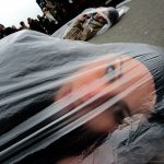 #34 A Member Of The “Women In Black”, An International Peace Network, Lays On The Ground Wrapped In A Plastic Bag, As A Sign Of Protest In Downtown Novi Sad, Serbia, 10 December 2005