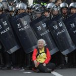 #6 A Woman Sits In Front Of Riot Police Blocking The Road To Protect Protesters During The Anti-Government Protest In Seoul, South Korea, 24 April 2015